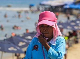 Una mujer se cubre del intenso calor en el balneario de Acapulco (México). EFE/David Guzmán
