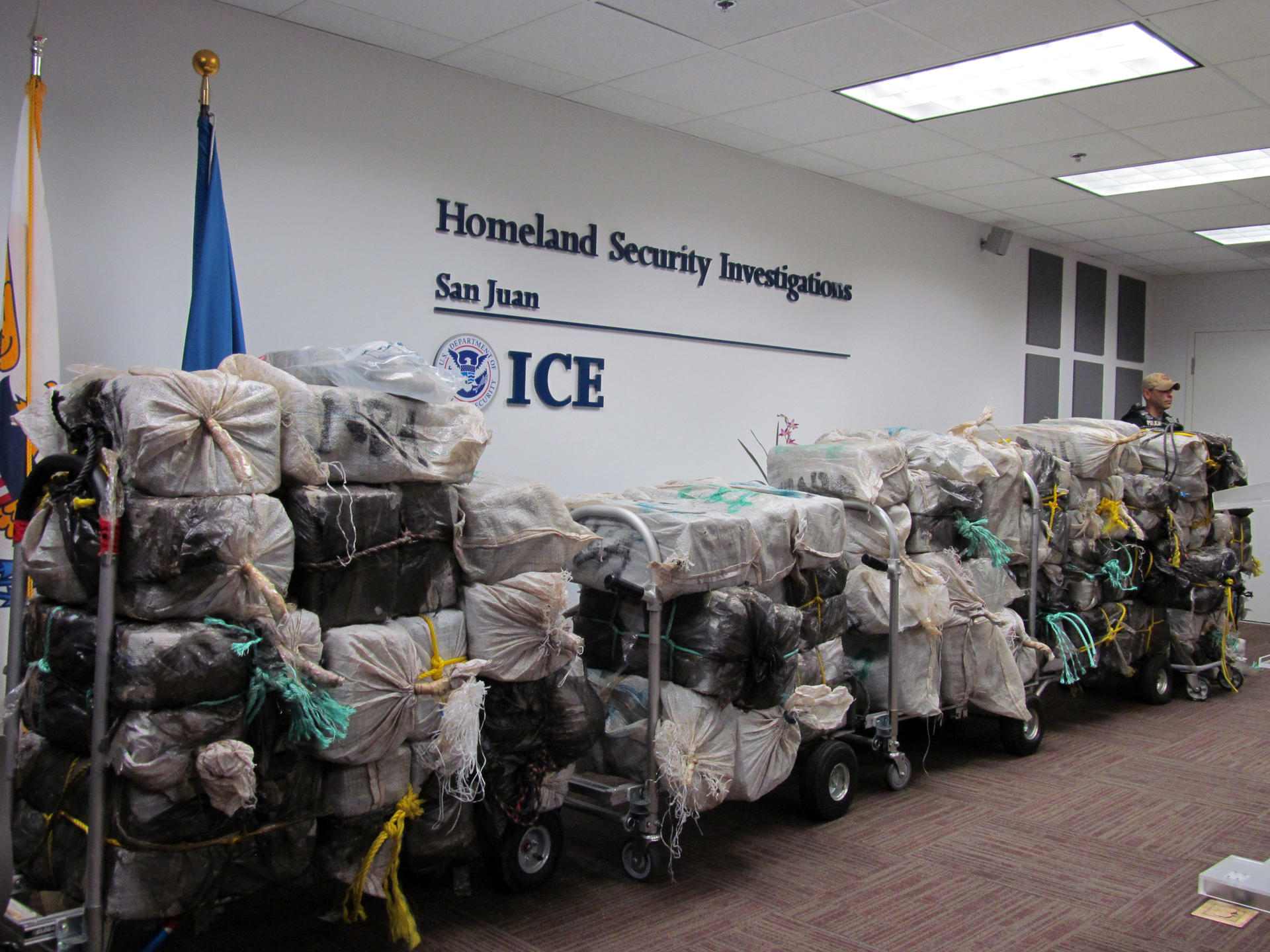 Un agente de la Agencia de Aduanas y Protección Fronteriza (ICE) custodia unos bultos que contienen kilos de cocaína durante su presentación en una rueda de prensa. Imagen de archivo. EFE/Jorge Muñiz
