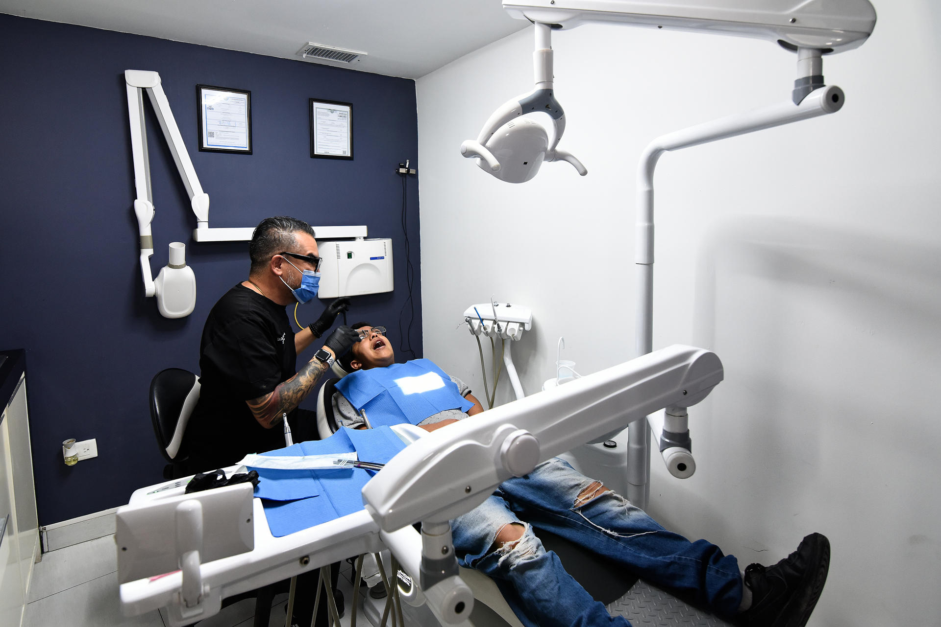 El cirujano maxilofacial de origen venezolano, Oswaldo Hernández Tabata, atiende  a un paciente en su consultorio dental el 16 de julio de 2023 en la fronteriza Ciudad Juárez, Chihuahua (México). EFE/Luis Torres
