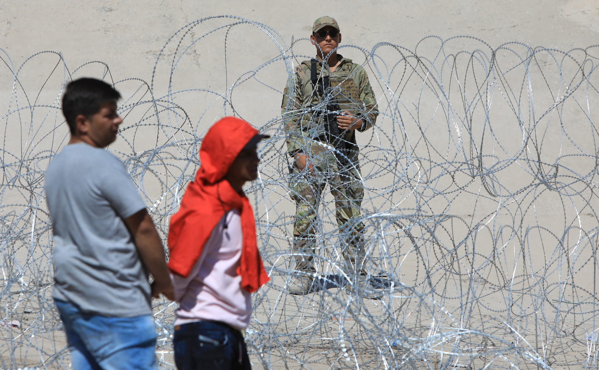 Un grupo de migrantes permanecen a un costado de la frontera con Estados Unidos vigilada por personal de la Guardia Nacional hoy, en Ciudad Juárez, Chihuahua (México). EFE/Luis Torres
