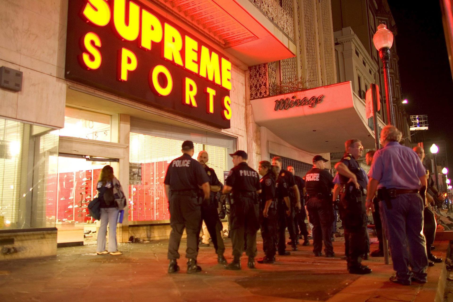 Fotogtafía de archivo de policías estadounidenses que vigilan fuera de unos almacenes luego de que unos 30 saqueadores entraron en la tienda y robaron mercancías. EFE/CHRIS LIVINGSTON

