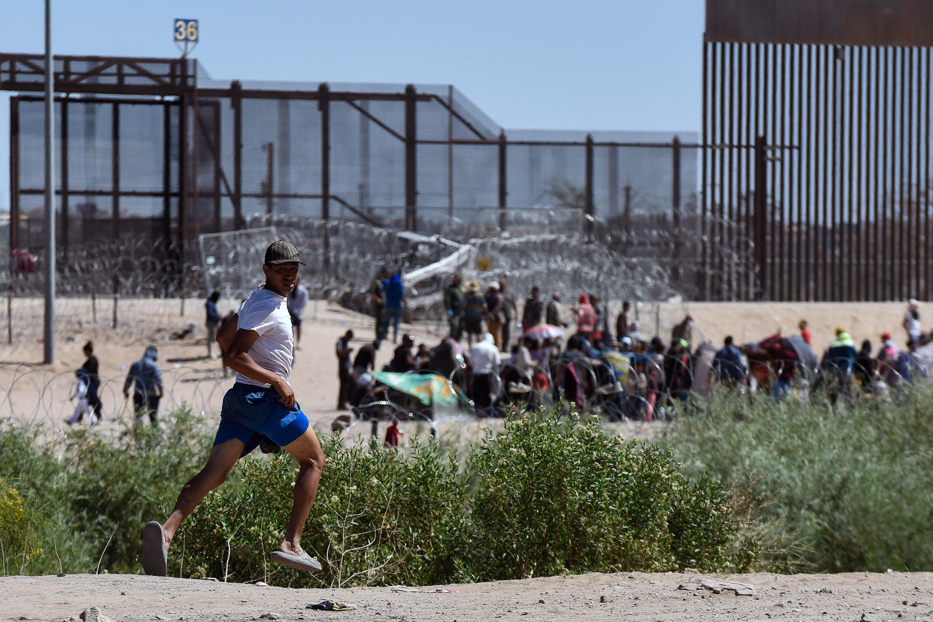 Un migrante corre ante la presencia de operativos de patrullaje en la frontera con Estados Unidos en Ciudad Juárez (México). EFE/Luis Torres
