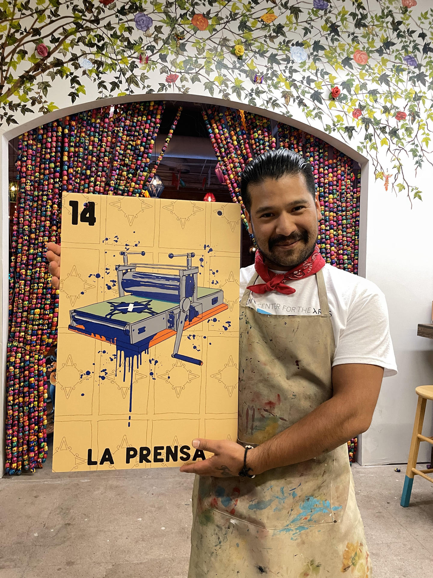 El tradicional juego de Lotería impulsa a artistas latinos y promueve negocios en Phoenix Fotografía cedida por Taller de Arte Xico donde aparece su coordinador Julián Miranda, quien es uno de los artistas participantes en el evento llamado DTPHX Lotería, mientras posa con una carta, La prensa, de la lotería de cartas en Phoenix, Arizona. EFE/Taller de Arte Xico /SOLO USO EDITORIAL /NO VENTAS /SOLO DISPONIBLE PARA ILUSTRAR LA NOTICIA QUE ACOMPAÑA /CRÉDITO OBLIGATORIO