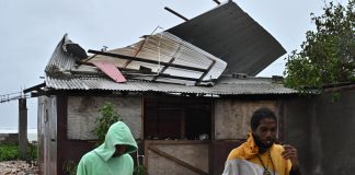 Jamaica espera el huracán Melissa mientras Cuba se prepara para posibles inundaciones Personas pasan frente a una casa afectada por los vientos preliminares del huracán Melissa este lunes, en la playa pesquera de Hellshire, en Portmore (Jamaica). EFE/Rudolph Brown