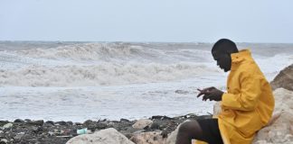 Cerca de 240.000 clientes sin luz en Jamaica por las fuertes lluvias del huracán Melissa Una persona revisa su teléfono frente al fuerte oleaje provocado por el paso del huracán Melissa este martes, en Kingston (Jamaica). EFE/Rudolph Brown