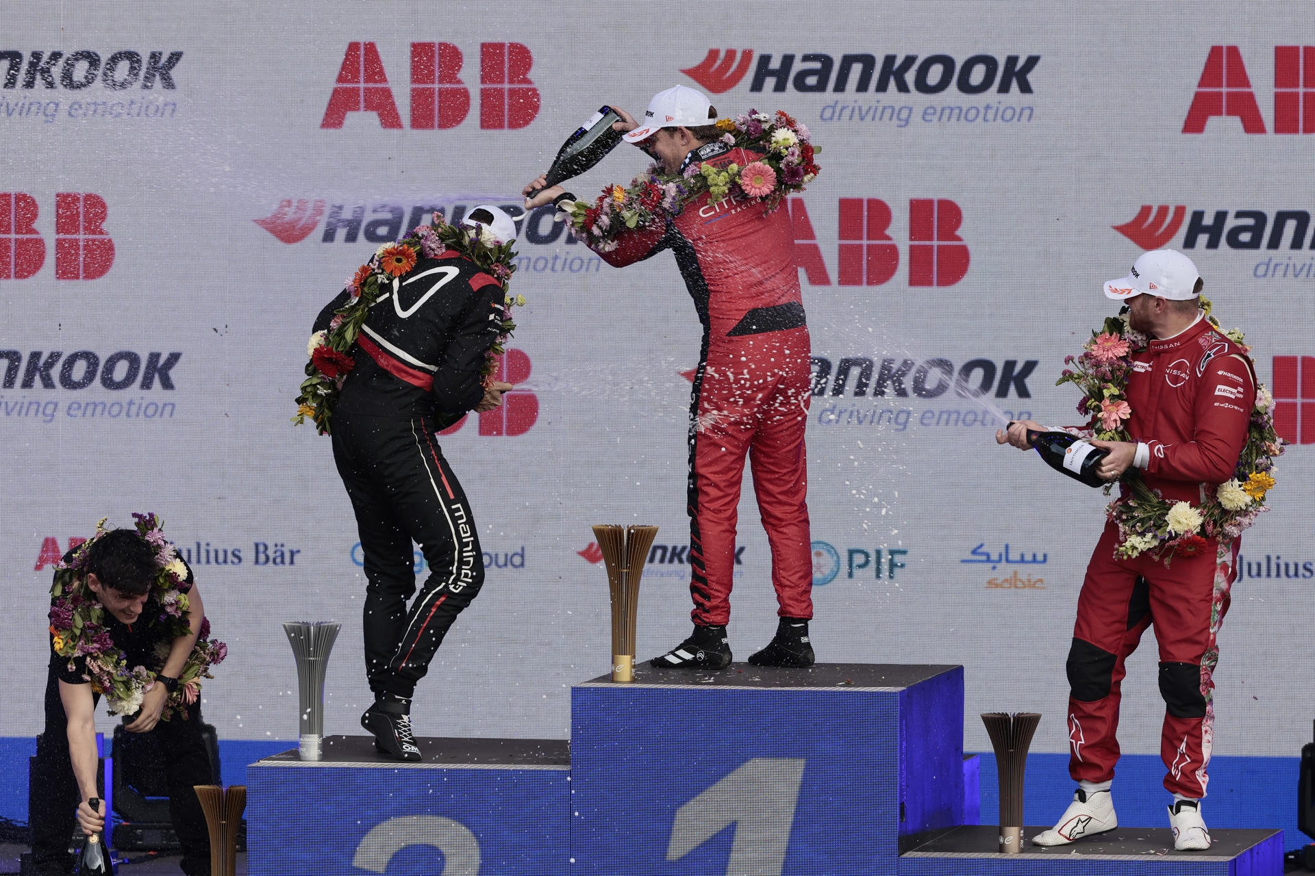El piloto neozelandés Nick Cassidy de Citroën (c) celebra en el podio la conquista del Gran Premio de México de la Fórmula E junto a sus primeros escoltas, el suizo Edoardo Mortara de Mahindra Racing (2-i) y al britanico Oliver Rowland de Nissan. EFE/ José Méndez
