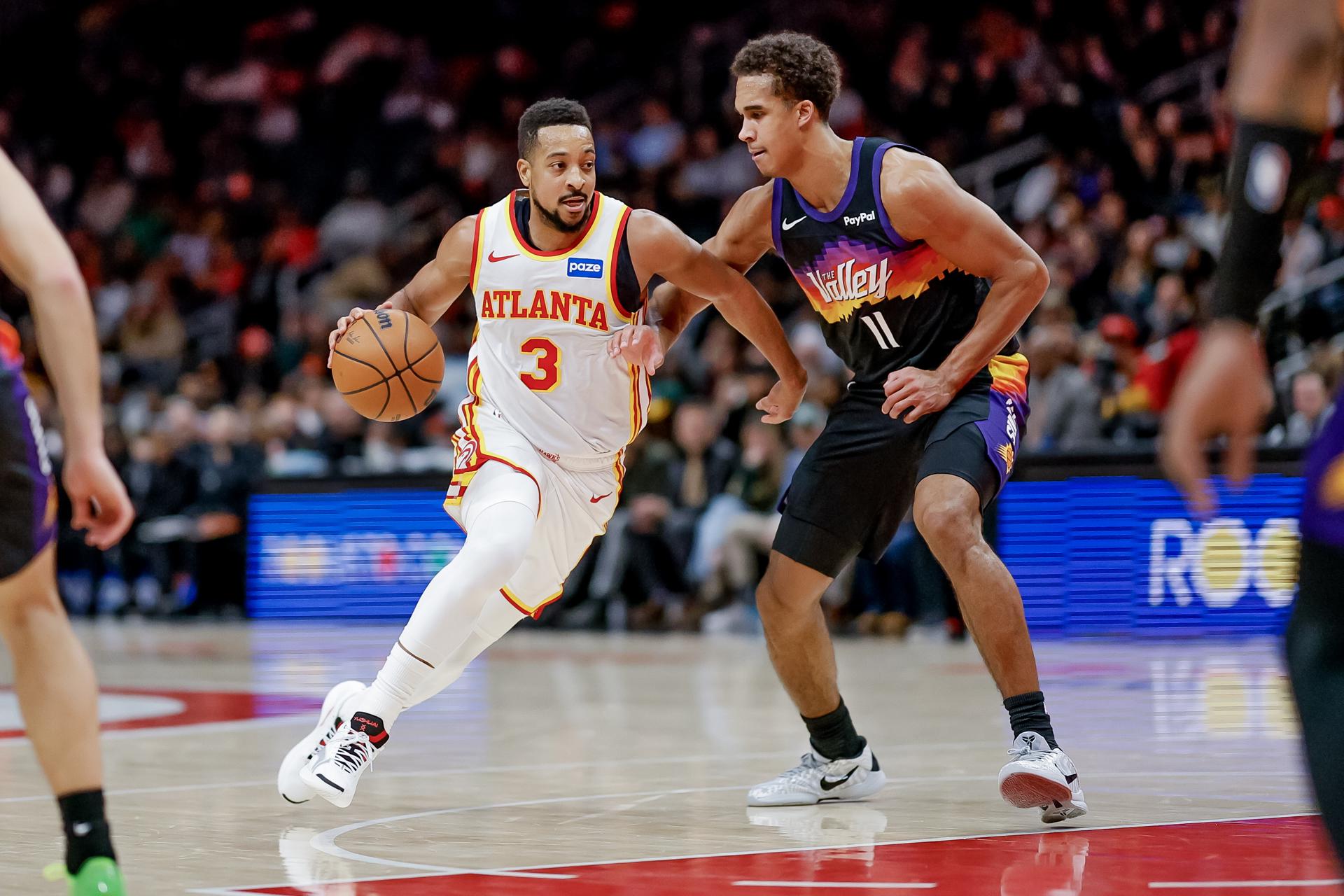 El escolta de los Atlanta Hawks CJ McCollum (i) busca superar la marca del alero de los Phoenix Suns Oso Ighodaro (d) durante el juego de este viernes en Atlanta (Georgia) EFE/EPA/ERIK S. LESSER SHUTTERSTOCK OUT
