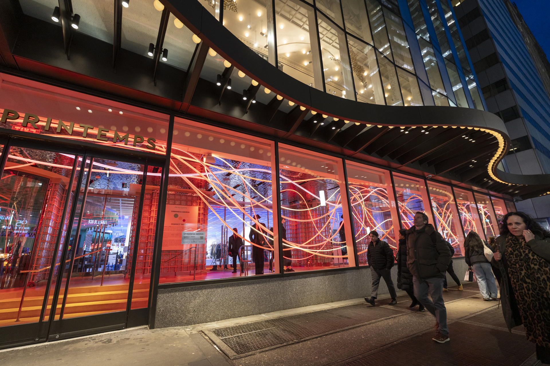 Personas pasan frente a la inauguración de una muestra de luces LED este jueves, en Wall Street, Nueva York (Estados Unidos). EFE/ Angel Colmenares