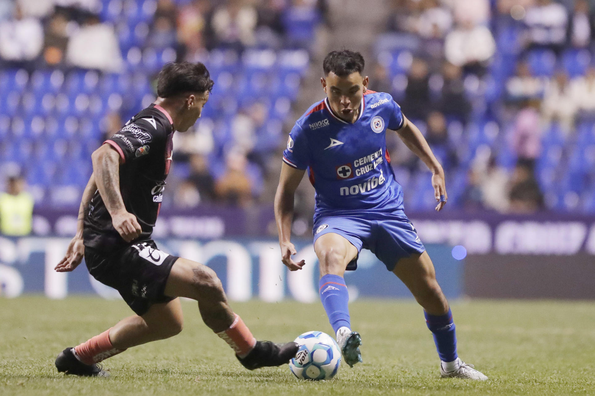 El delantero de Cruz Azul Carlos Rodríguez (d) disputa el balón con el defensor de Puebla Pablo Gamarra (i) este sábado, durante un partido de la tercera jornada del torneo Clausura mexicano jugado en el estadio Cuauhtémoc de Puebla. EFE/ Hilda Ríos
