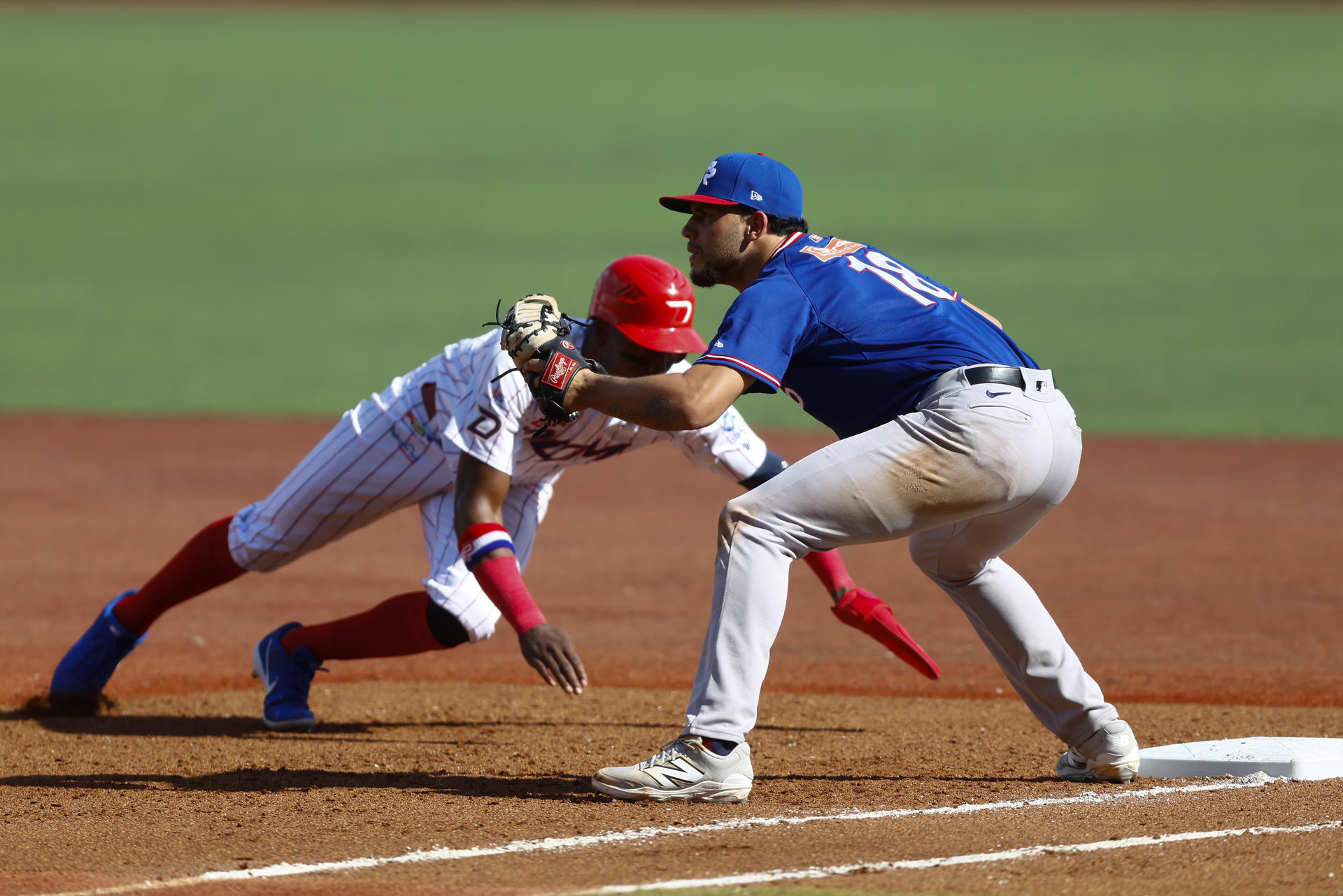 Junior Lake (i) de los Leones del Escogido de República Dominicana se barre a primera base ante Yohandy Morales, de los Cangrejeros de Santurce de Puerto Rico este lunes durante el juego de la segunda jornada de la Serie del Caribe de Béisbol en el Estadio Panamericano de Guadalajara. EFE/ Francisco Guasco
