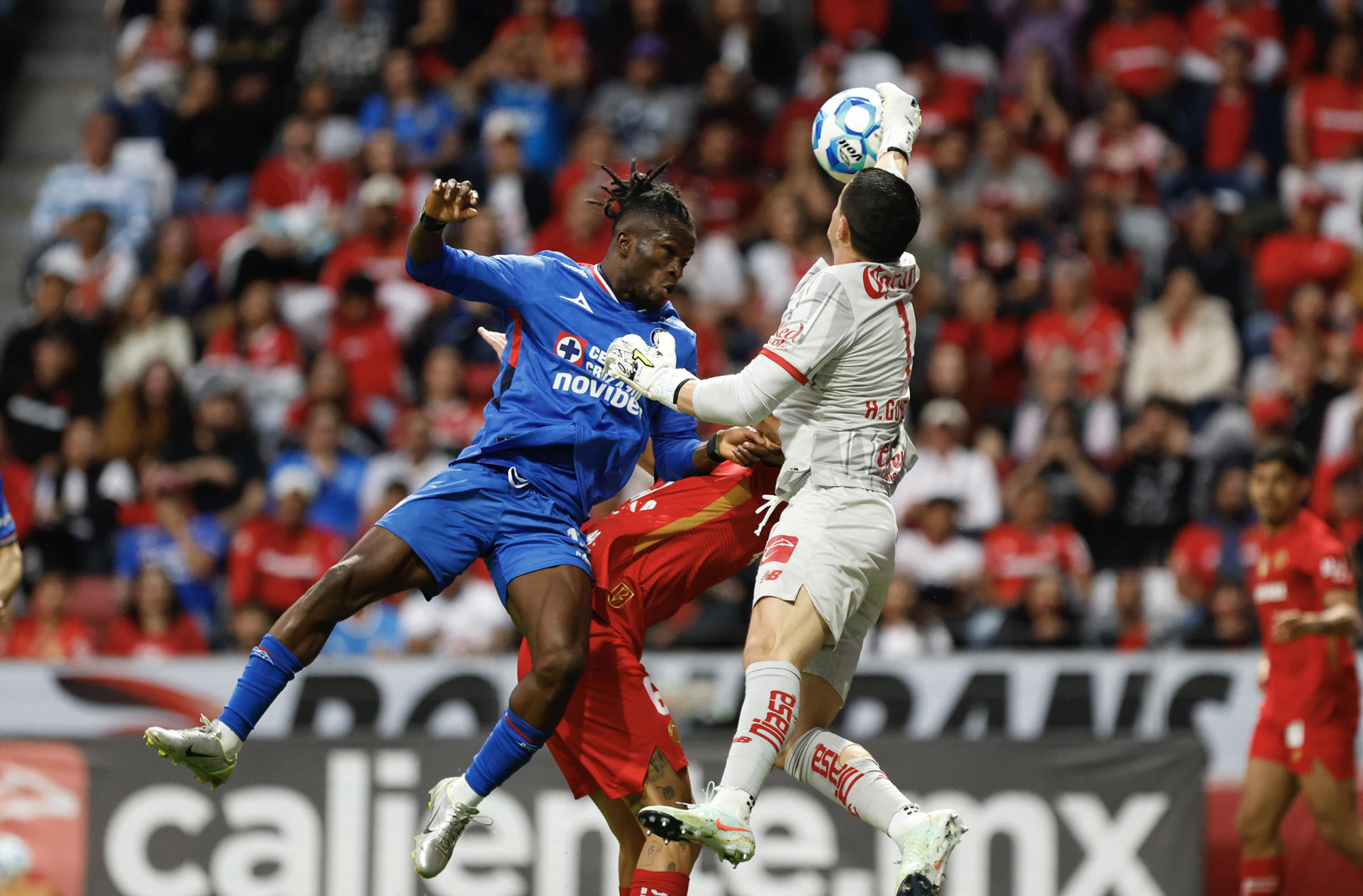 El portero de Toluca Hugo González (d) evita un cabezazo del extremo nigeriano de Cruz Azul, Osinachi Ebere (i) este sábado, durante un partido del Torneo Clausura mexicano que terminó 1-1 en el estadio Nemesio Diez. EFE/Felipe Gutiérrez
