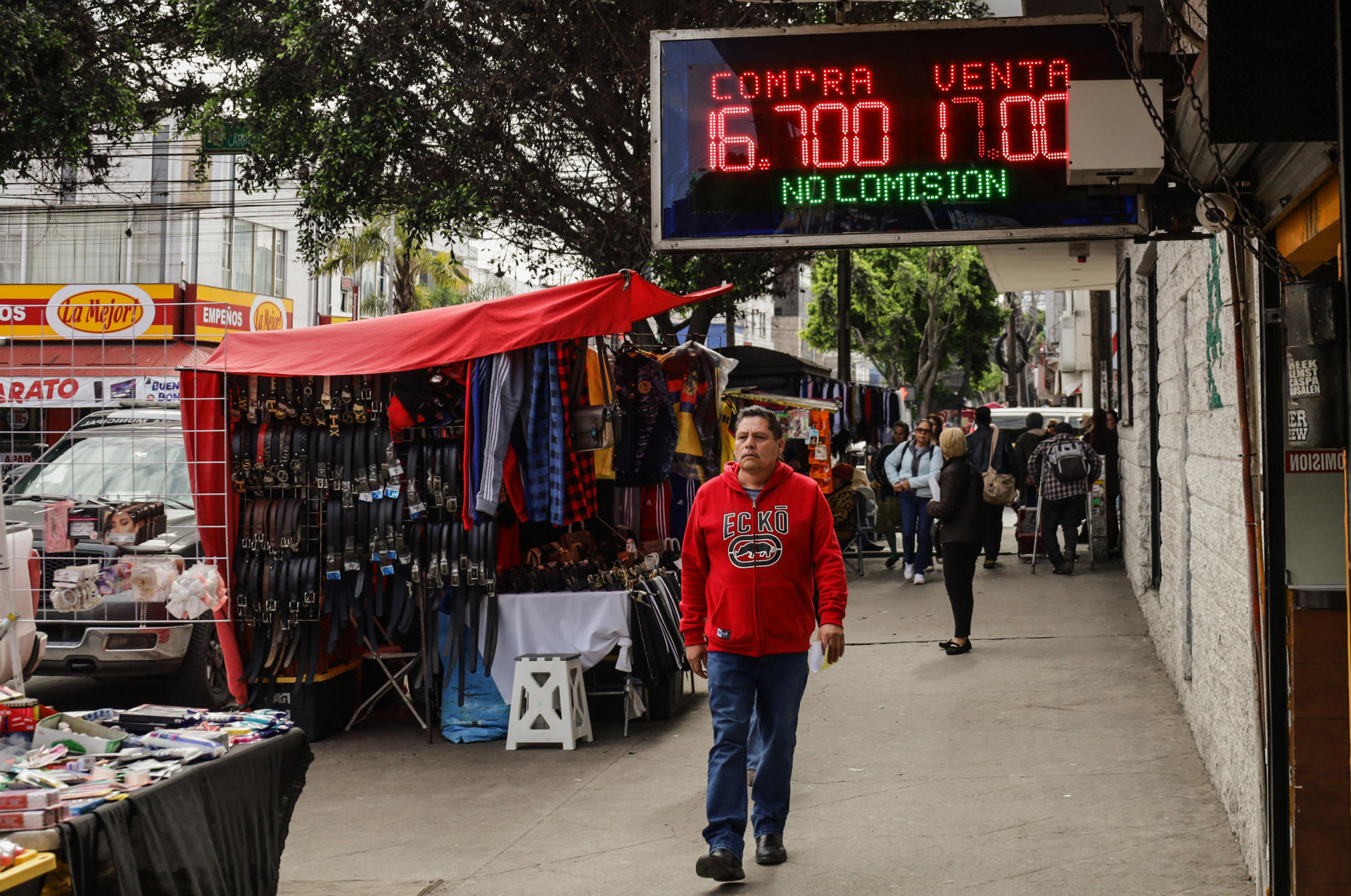Una persona camina frente a una casa de cambio este viernes, en la ciudad de Tijuana (México). EFE/ Joebeth Terríquez
