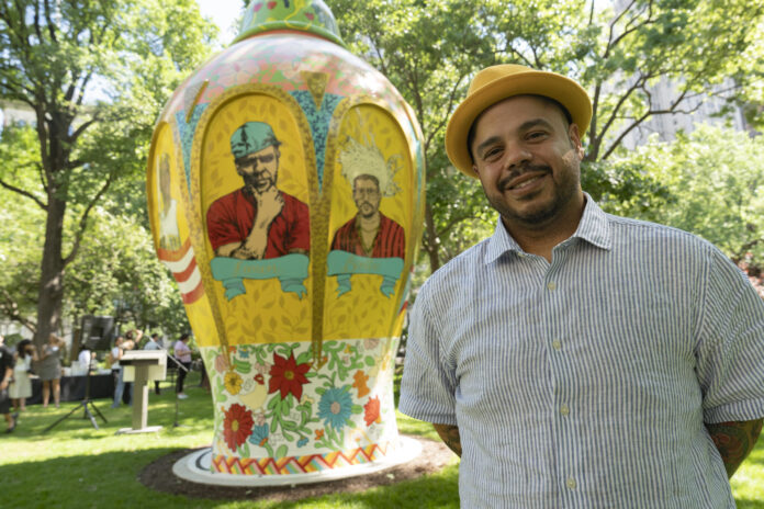 El artista y poeta puertorriqueño Roberto Lugo posa junto a su escultura 'Alfarero del barrio' expuesta este miércoles, en el Madison Square Park en Nueva York (EE.UU). EFE/ Angel Colmenares
