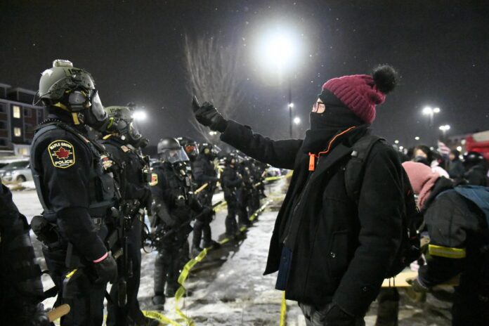 Fotografía de archivo del 27 de enero de 2026 que muestra a un manifestante protestando frente a integrantes de la policía durante un operativo en Maple Grove, un suburbio de Minneapolis (EE.UU.). EFE/EPA/CRAIG LASSIG
