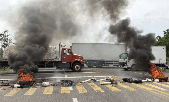 Fotografía de llantas incendiadas durante un bloqueo con camiones de la Coordinadora Nacional de Trabajadores de la Educación (CNTE) este miércoles, en Villa de Mitla en Oaxaca (México). EFE/Jesús Méndez
