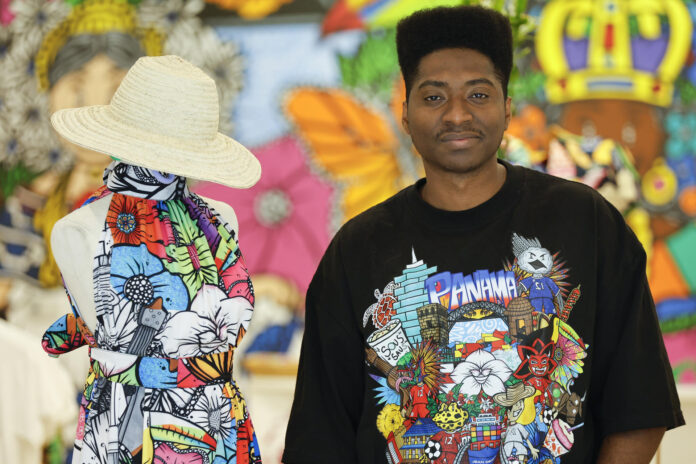 Fotografía del 12 de mayo que muestra al artista colonense Jean Quijano posando con uno de sus diseños en su tienda de moda Jean Decort en ciudad de Panamá (Panamá). EFE/ Bienvenido Velasco
