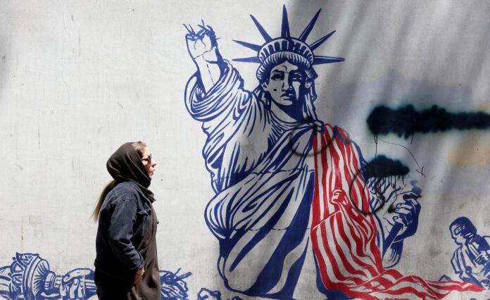 Una mujer iraní camina junto a un mural anti-estadounidense cerca de la antigua embajada de EE. UU. en Teherán, Irán, este martes 26 de mayo de 2026. EFE/EPA/ABEDIN TAHERKENAREH
