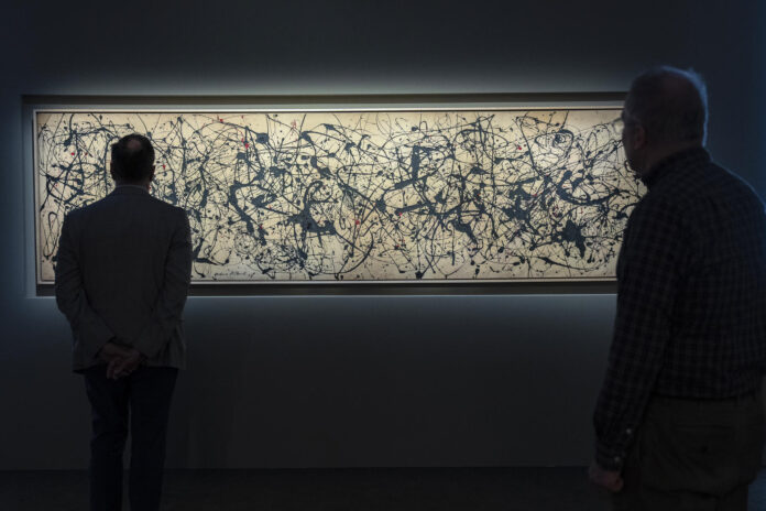 Un par de hombres fue captado este 13 de mayo al observar la pintura de Jackson Pollock (1912-1956), 'Number 7A' (1948), que será subastada por la casa Christies, en Nueva York (NY, EE.UU.). EFE/Ángel Colmenares
