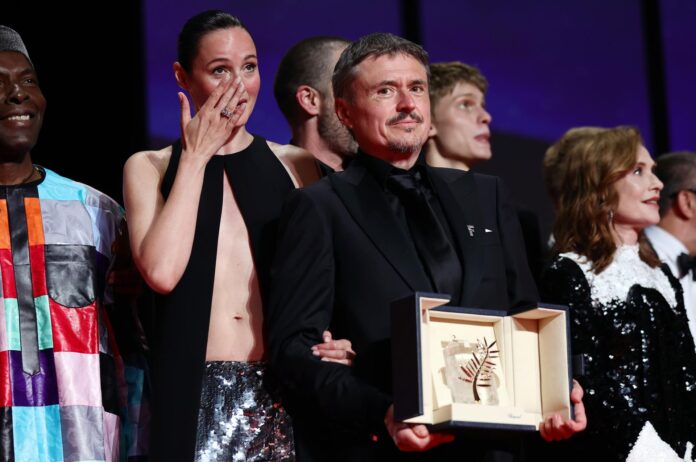 Renate Reinsve (i) y Cristian Mungiu (c) en el escenario con la Palma de Oro por 'Fjord' durante la ceremonia de clausura del 79º Festival de Cine de Cannes (Francia). EFE/EPA/TERESA SUAREZ
