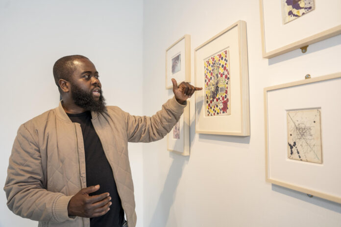 El cofundador y copropietario de The Bishop Gallery, Erwin John, muestra obras del artista estadounidense Jean-Michel Basquiat durante una exposición en Nueva York (EE.UU.). EFE/ Ángel Colmenares
