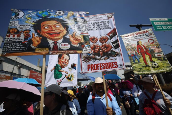 Maestros de la Coordinadora Nacional de Trabajadores de la Educación (CNTE), sostienen carteles durante una protesta este viernes, en Ciudad de México (México). EFE/ Sáshenka Gutiérrez
