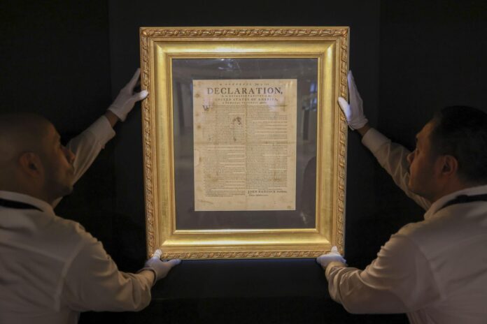Fotografía de archivo del 17 de enero de 2026 que muestra a personas sosteniendo la Declaración de Independencia: el folleto de Exeter de julio de 1776 en la casa de subastas Sotheby’s de Nueva York (EE.UU.). EFE/ Sarah Yenesel/ ARCHIVO
