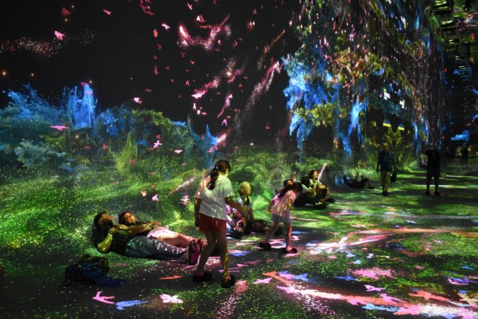 Personas asisten a la exposición inmersiva 'Machine Dreams: Rainforest' (Sueños de máquina: Selva tropical) este lunes, en Dataland, el primer museo de IA, concebido por Refik Anadol Studio, en Los Ángeles (EE.UU.). EFE/ Mónica Rubalcava
