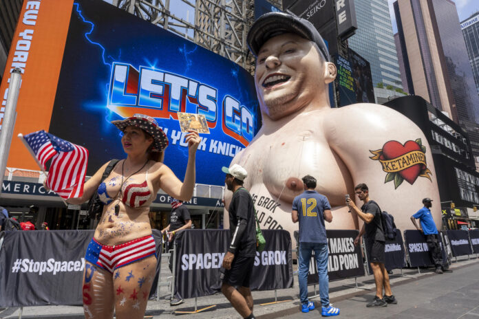 Personas se manifiestan por el lanzamiento a la bolsa de SapaceX frente a un muñeco inflable gigante con la cara de Elon Musk este jueves, en Times Square de Nueva York (EE.UU.). EFE/ Ángel Colmenares
