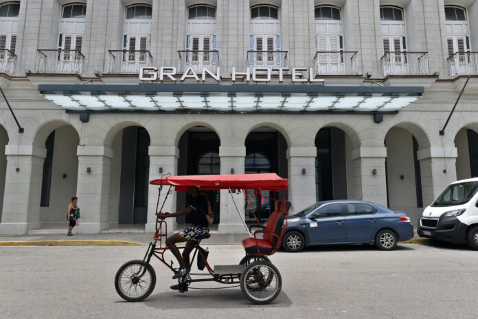 Personas transitan frente a un hotel este miércoles, en La Habana (Cuba). EFE/ Ernesto Mastrascusa
