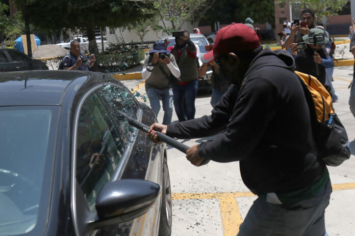 Una persona vandaliza un vehículo este martes, durante una protesta de integrantes de la Coordinadora Nacional de Trabajadores de la Educación (CNTE), en Chilpancingo (México). EFE/ José Luis De La Cruz
