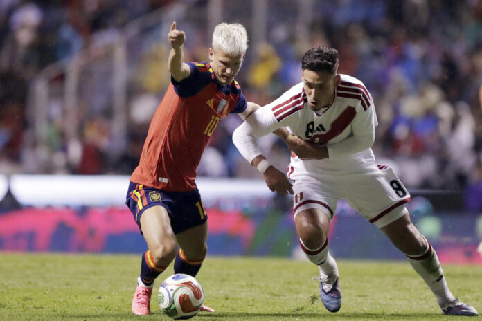 Dani Olmo (i) de España disputa un balón con Rrick Noriega (d) de Perú en un partido amistoso entre España y Perú previo al Mundial de Fútbol 2026 en el estadio Cuauhtémoc en Puebla (México). EFE/ Hilda Ríos
