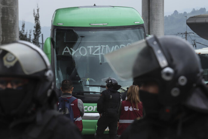 Integrantes de la Secretaría de Seguridad de México bloquean el paso de buses donde viajan estudiantes de Ayotzinapan que se dirigen al Zócalo para manifestarse junto a la Coordinación Nacional de Trabajadores de la Educación (CNTE) este lunes, en el peaje de Tlalpan, al sur de la Ciudad de México (México). EFE/ Madla Hartz
