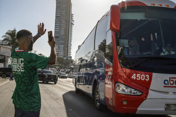 Una persona saluda a los jugadores de Irán a bordo de un autobús este miércoles, en Tijuana (México). EFE/ Joebeth Terríquez
