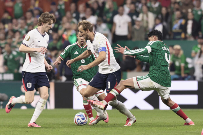 Edson Álvarez (d) de México disputa el balón con Harry Kane (c) de Inglaterra este domingo, en un partido de los octavos de final del Mundial de la FIFA 2026 entre México e Inglaterra en el estadio Azteca en la Ciudad de México (México). EFE/ José Méndez

