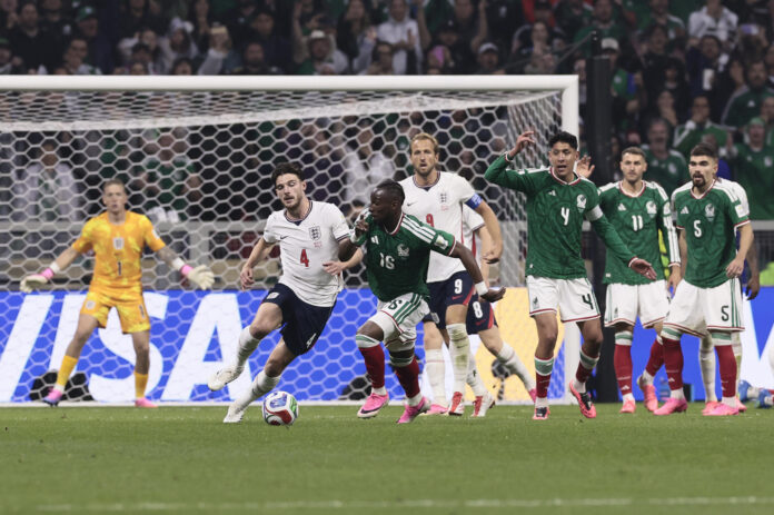 Julián Quiñones (c) de México disputa el balón con Declan Rice (i) de Inglaterra este domingo, en un partido de los octavos de final del Mundial de la FIFA 2026 entre México e Inglaterra en el estadio Azteca en la Ciudad de México (México).EFE/ José Méndez

