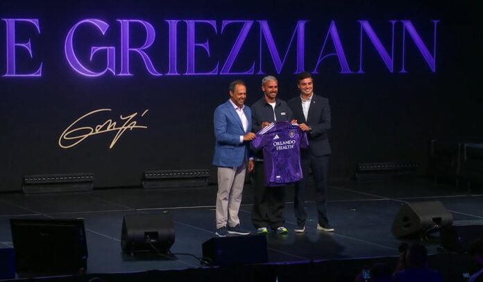 Captura de un video difundido por el equipo de la MLS Orlando City del futbolista francés Antoine Griezmann (c) posando con el dueño y presidente del Orlando City Mark Wilf (i) y el director deportivo Ricardo Moreira este martes, durante su presentación como nuevo jugador, en Orlando (FL, EE.UU.). EFE/Orlando City /SOLO USO EDITORIAL/ SOLO DISPONIBLE PARA ILUSTRAR LA NOTICIA QUE ACOMPAÑA (CRÉDITO OBLIGATORIO)
