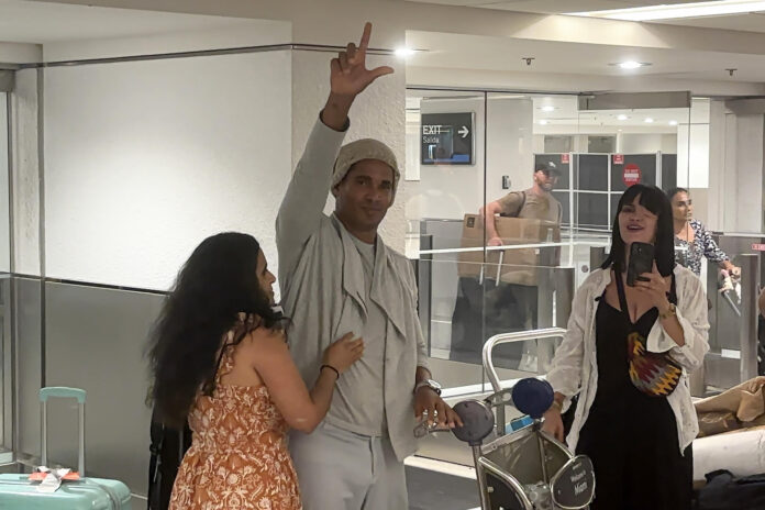 El artista plástico y opositor cubano Luis Manuel Otero Alcántara (c) saluda a su llegada este sábado a Miami, tras recuperar la libertad en la isla y recibir un amparo migratorio de Estados Unidos, después de cinco años encarcelado en Cuba. EFE/ Pablo Urbón
